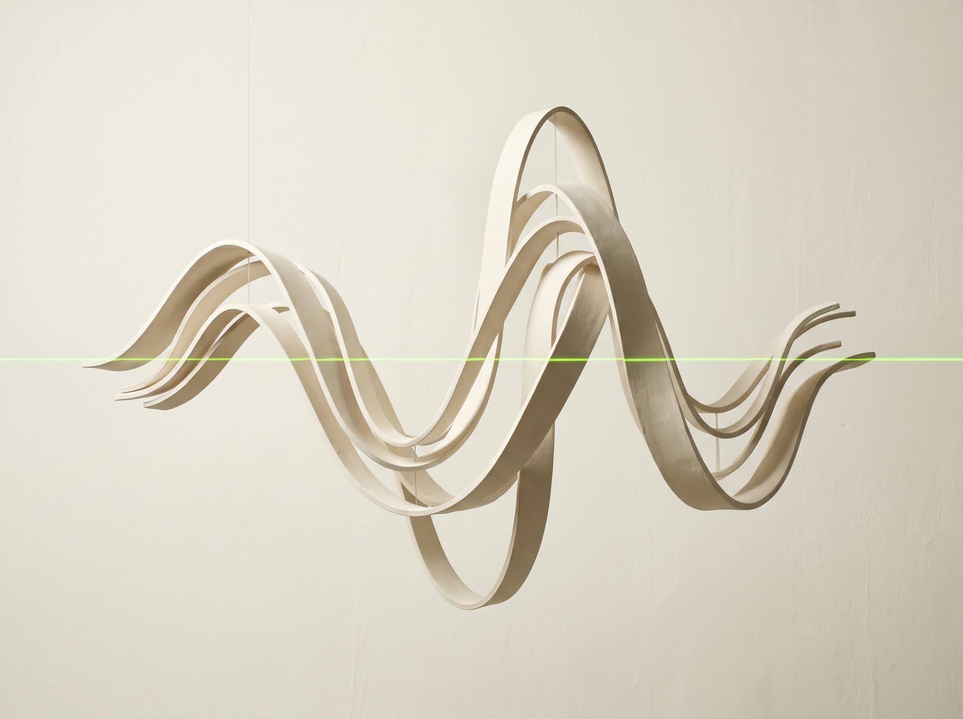 Waveform sculpted in physical material with an acid-lime laser cutting through